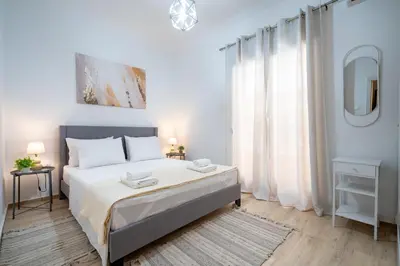 a white bedroom with a large bed and a mirror at Cozy central apartment for 2 person by MPS in Athens