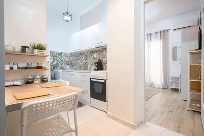 a kitchen with white cabinets and a counter top at Cozy central apartment for 2 person by MPS in Athens