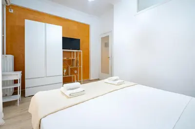 a white bedroom with a bed and a tv at Cozy central apartment for 2 person by MPS in Athens
