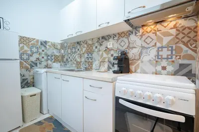 a kitchen with white cabinets and a stove top oven at Cozy central apartment for 2 person by MPS in Athens