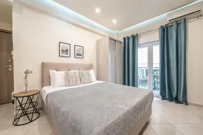a bedroom with a bed and a large window at Cozy Apartment in Athens