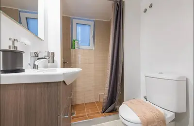a bathroom with a sink and a toilet and a shower at Cozy Apartment in Athens