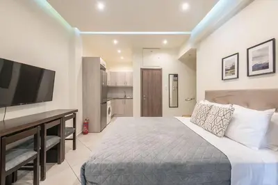a bedroom with a large bed and a flat screen tv at Cozy Apartment in Athens