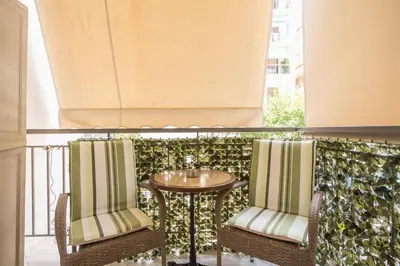 a balcony with two chairs and a table on a balcony at Cozy Apartment in Athens