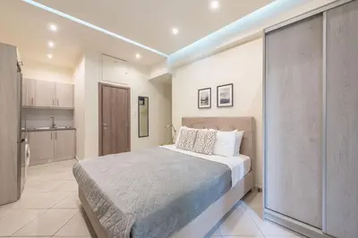 a bedroom with a large bed and a kitchen at Cozy Apartment in Athens