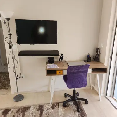 a computer desk with a monitor and a purple chair at Elite Port in Piraeus