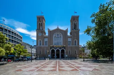 a large building with a clock tower on a street at Athensis Acropolis View next to Ermou street! in Athens