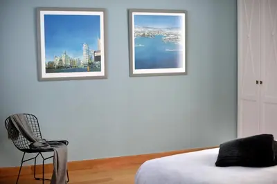 a bedroom with two pictures on the wall and a chair at Outstanding Athens Apartment Karyatis Luxury Maisonette 3 Bedrooms in Athens