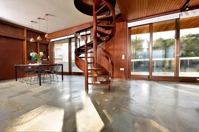a living room with a spiral staircase and a table at Outstanding Athens Apartment Karyatis Luxury Maisonette 3 Bedrooms in Athens