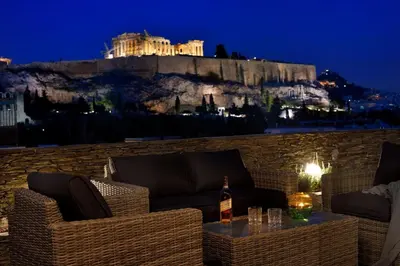 a patio with chairs and a table with a bottle of wine at Outstanding Athens Apartment Karyatis Luxury Maisonette 3 Bedrooms in Athens