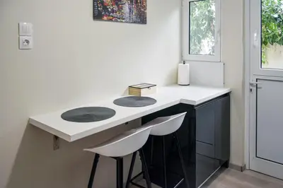 a kitchen with a counter with two stools at Apartment in Alimos in Athens