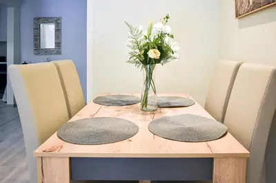 a wooden table with a vase of flowers on it at Apartment in Alimos in Athens