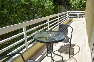 a glass table and two chairs on a balcony at Apartment in Alimos in Athens