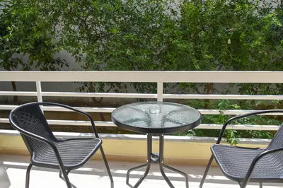 a glass table and two chairs on a porch at Apartment in Alimos in Athens