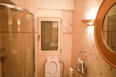 a bathroom with a toilet and a shower and a mirror at Luxury Villa with Pool in Athens Riviera in Lagonissi