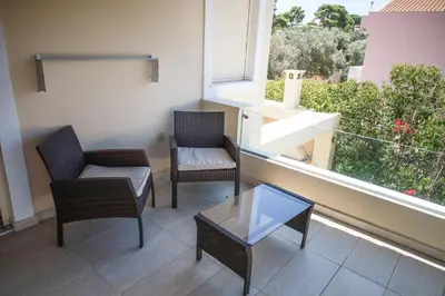 a balcony with two chairs and a table and a window at Luxury Villa with Pool in Athens Riviera in Lagonissi