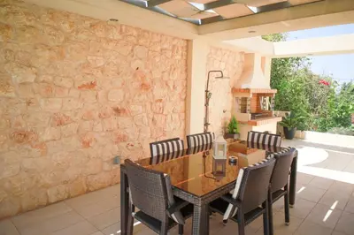 a dining room with a wooden table and chairs at Luxury Villa with Pool in Athens Riviera in Lagonissi