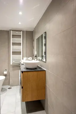 a bathroom with a sink on a counter with a mirror at Spacious and modern one bedroom apartment in Athens