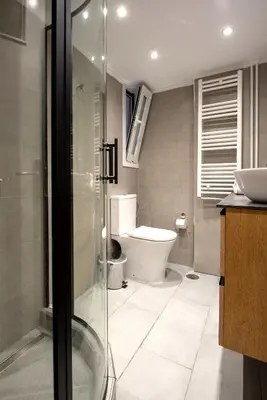 a bathroom with a toilet and a glass shower at Spacious and modern one bedroom apartment in Athens