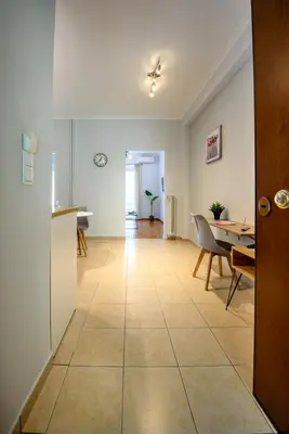 a living room with a kitchen and a table at Spacious and modern one bedroom apartment in Athens