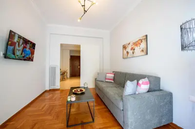 a living room with a couch and a table at Spacious and modern one bedroom apartment in Athens