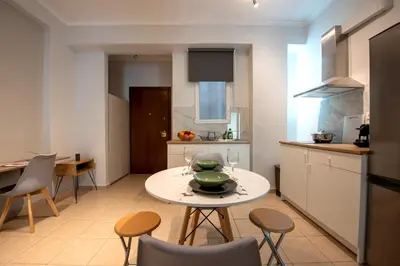 a kitchen with a table and chairs in a kitchen at Spacious and modern one bedroom apartment in Athens
