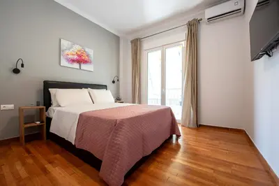 a bedroom with a bed and a large window at Spacious and modern one bedroom apartment in Athens