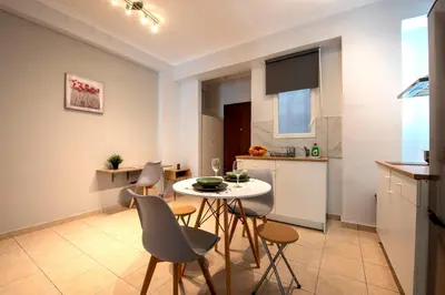 a kitchen and dining room with a table and chairs at Spacious and modern one bedroom apartment in Athens