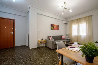 a living room with a table and a couch at Spacious and modern one bedroom apartment in Athens