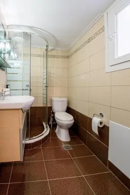 a bathroom with a toilet and a sink and a shower at Spacious and modern one bedroom apartment in Athens