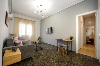a living room with a couch and a table at Spacious and modern one bedroom apartment in Athens