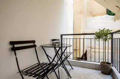 a chair and a table on a balcony at Spacious and modern one bedroom apartment in Athens