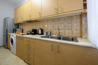 a kitchen with a sink and a refrigerator at Spacious and modern one bedroom apartment in Athens
