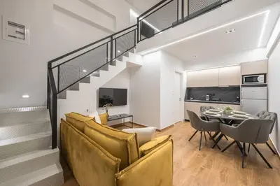 a living room with a staircase and a dining room at Athens Loft in Athens