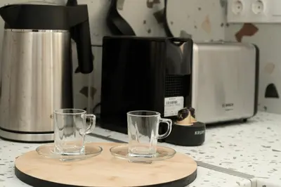 two glasses on a cutting board next to a coffee maker at Tsil House in Athens