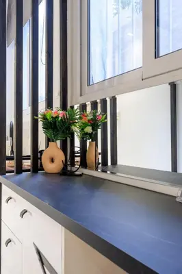 a kitchen counter with two vases with flowers on it at Aiolos luxury apartment under acropolis in plaka in Athens