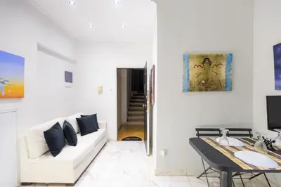 a white living room with a white couch and a table at Aiolos luxury apartment under acropolis in plaka in Athens