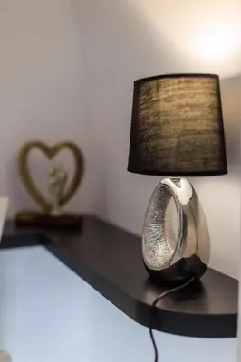 a table with a lamp and ainylinylinylinylinylinylinylinylinyl at Aiolos luxury apartment under acropolis in plaka in Athens