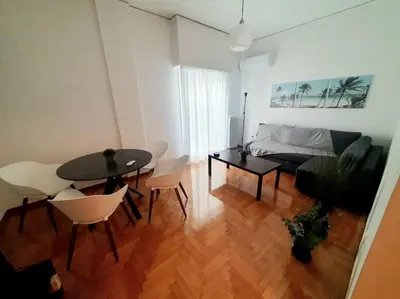 a living room with a table and chairs and a couch at George's Cozy 60m2 Apartment 7' Metro in Athens