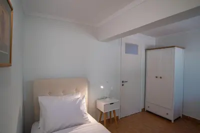 a bedroom with a white bed and a white door at Oregano peaceful complex in Porto Rafti