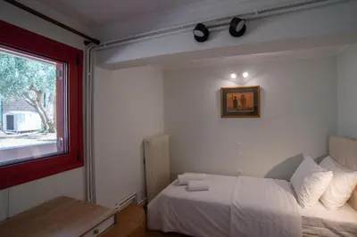 a small bedroom with a bed and a window at Oregano peaceful complex in Porto Rafti