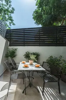 a table and chairs sitting on a patio at The Meta Stay - Backyard Oasis with Rooftop Access in Athens