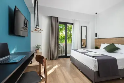 a bedroom with a bed and a desk with a laptop at The Meta Stay - Sunny Retreat with Rooftop Access in Athens
