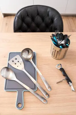 a wooden table with spoons and a container of utensils at The Meta Stay - Sunny Retreat with Rooftop Access in Athens