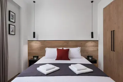 a bedroom with a large bed with two red pillows at The Meta Stay - Rooftop Access Downtown Suite in Athens