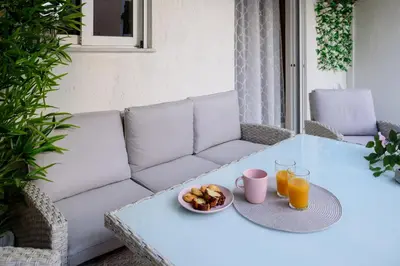 a table with a couch and a plate of food on it at Charming apartment Galatsi for 5 by MPS in Athens