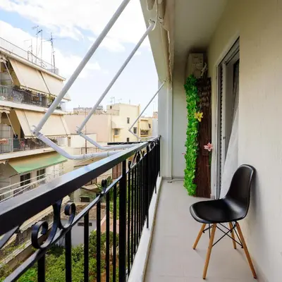 a black chair sitting on a balcony with a view at Charming apartment Galatsi for 5 by MPS in Athens