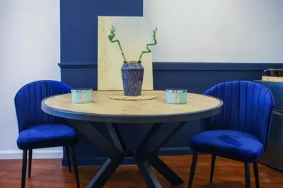 a table with two blue chairs and a vase on it at The Captain Suite in Athens