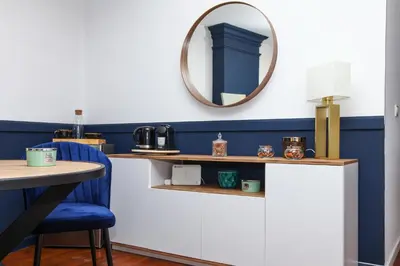 a mirror on a wall next to a table with a chair at The Captain Suite in Athens