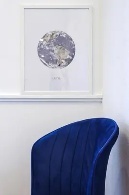 a blue chair sitting in front of a picture on a wall at The Captain Suite in Athens